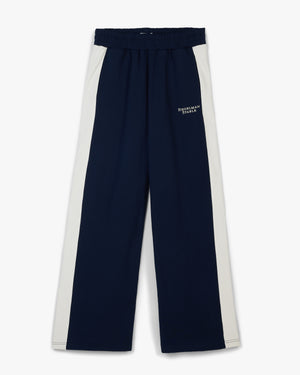 Front view of navy retro flared sweatpants with cream side panels and small white hip text