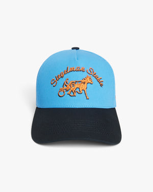 Front view of the New York Knicks x Siegelman Stable hat, light blue crown, black visor, orange script and horse logo