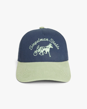 Front view of a navy and seafoam two-tone 5-panel cap with seafoam Siegelman Stable script and horse and sulky embroidery
