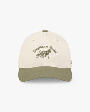 Front view of an ivory and taupe two-tone dad hat with taupe Siegelman Stable script and horse and sulky embroidery