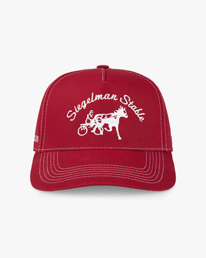 Front of the St. John's Red Storm x Siegelman Stable red hat with white script, horse logo and white stitching