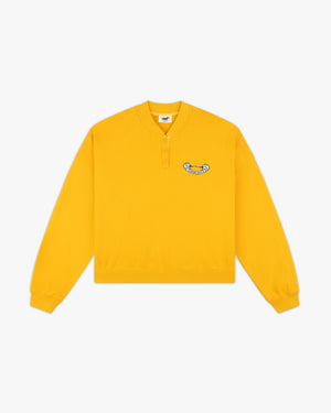 Front view of a yellow henley sweatshirt with button placket and Siegelman Stable crest patch on the chest