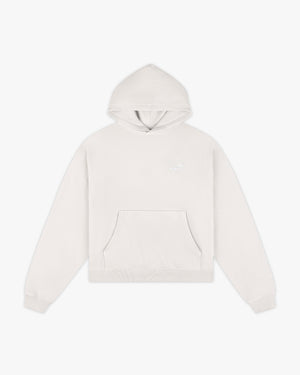 A light gray cropped hoodie with a front kangaroo pocket and a subtle tonal embroidered logo on the left chest, displayed against a clean white background.