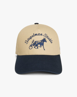 Front view of a khaki and navy two-tone 5-panel pro cap with navy Siegelman Stable script and horse and sulky embroidery