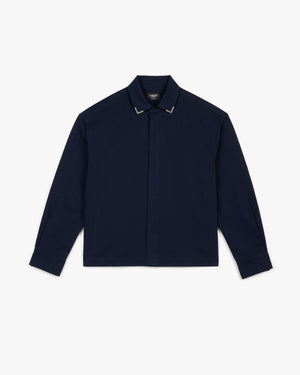 Front view of a navy collar tip button up shirt with silver metal collar tips and hidden placket