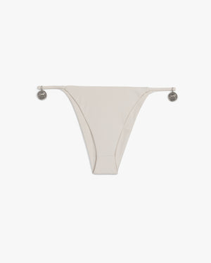 Front view of a beige string bikini bottom with silver horse pendants at the hips