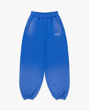 Front view of faded cobalt sweatpants with small white Siegelman Racing Stable text at the left hip