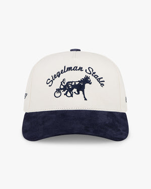 Front of the Indy 500 x Siegelman Stable hat, ivory crown with navy Siegelman Stable script, horse logo and navy visor