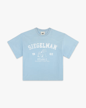 Front view of a celestial blue boxy tee with white arched Siegelman Stable collegiate graphic and horse