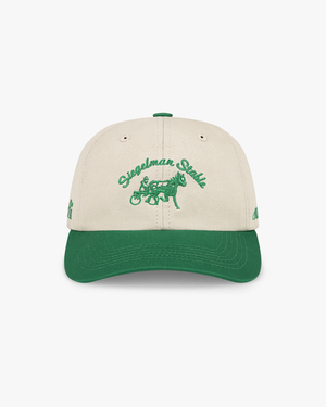 Front view of the Maxfli x Siegelman Stable dad hat, off-white crown, kelly green visor and green script and horse logo