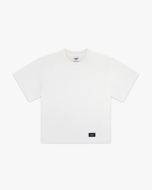 Front view of a bright white boxy tee with a small black Siegelman Stable woven label at the lower hem